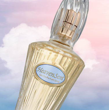 Editorial shot: close-Up of bottle of Heaven Sent eau de parfum spray on a background of pink purple clouds in sky