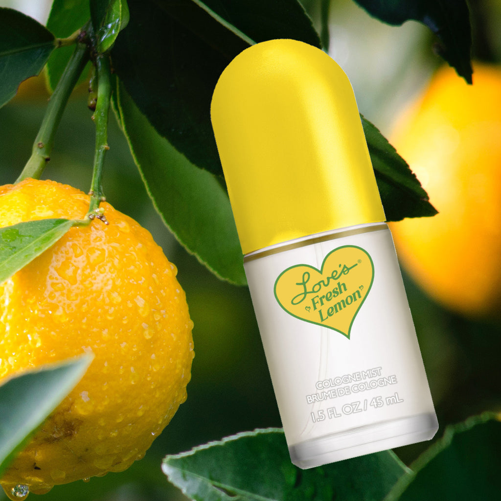 Editorial shot: bottle of Love's Fresh Lemon cologne mist hanging with lemons in tree, next to a lemon.